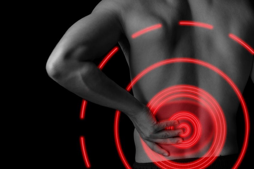 Man is touching the lower back, pain in the kidney, black and white image, pain area of red color