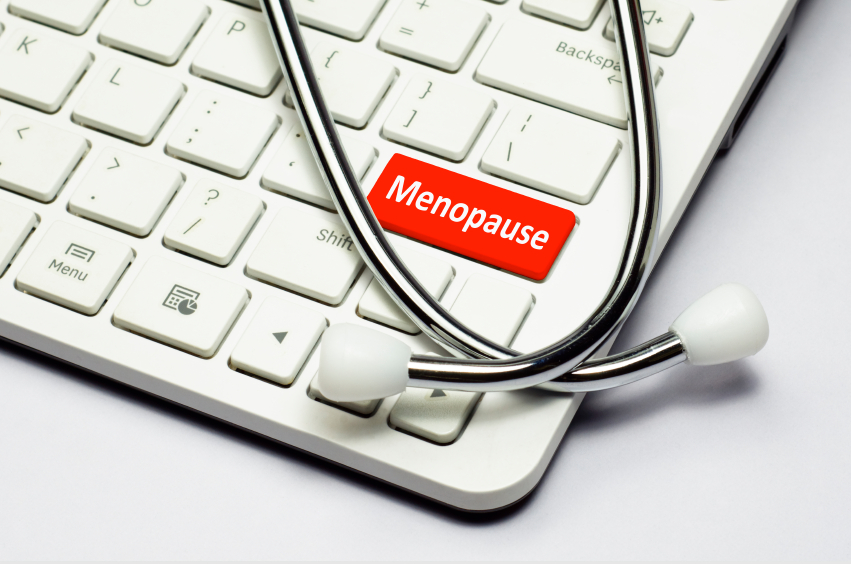 Menopause text, stethoscope lying down on the cumputer keyboard