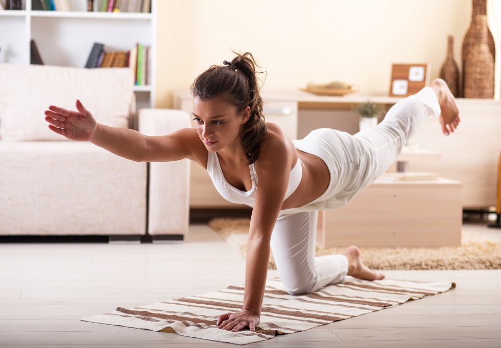 Young  woman doing yoga in her living room.